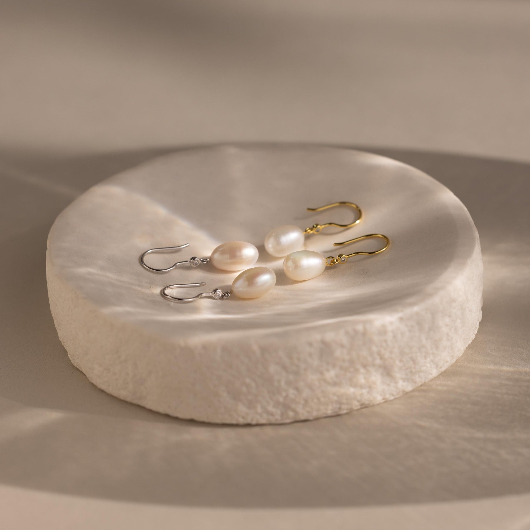 Brincos de pérolas e diamantes pendurados