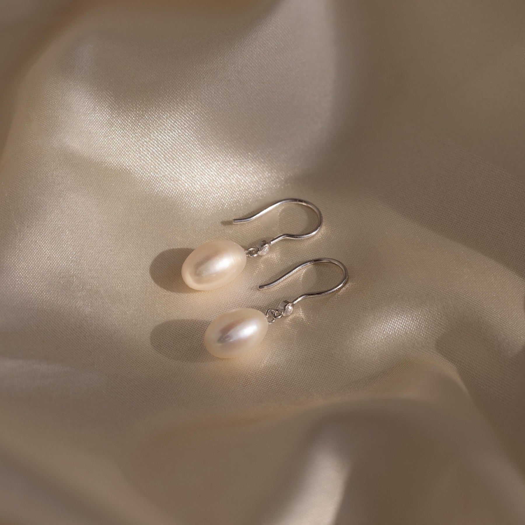 Brincos de pérolas e diamantes pendurados