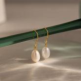 Brincos de pérolas e diamantes pendurados