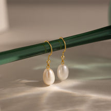 Brincos de pérolas e diamantes pendurados